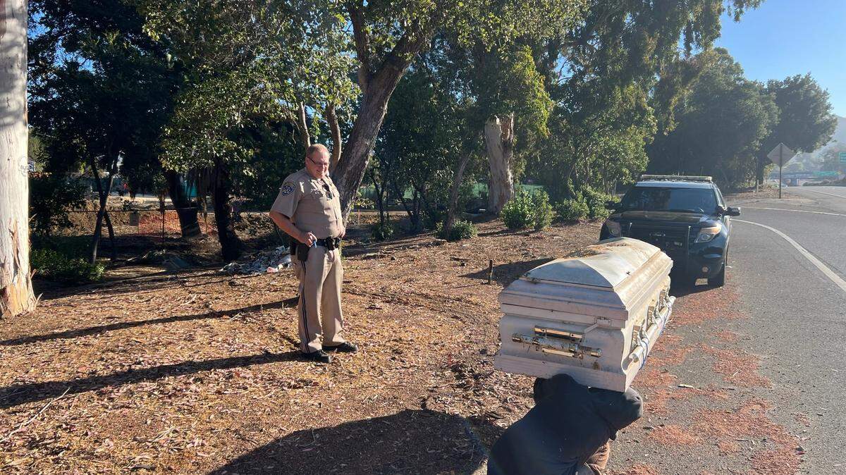 A California Highway Patrol officer stands by a funeral casket on the shoulder of Highway 101 in San Luis Obispo on Sunday, July 10, 2022.