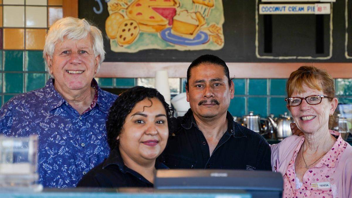 Coco’s Bakery Restaurant owner Larry Puder, left, stands with his staff on the second-to-last day of the restaurant’s operation, Feb. 14, 2023. Puder ran the Coco’s franchise in Pismo Beach for 25 years.