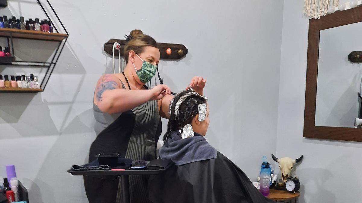 Cosmetologist and store owner Rachel Meredith of Grace & Raven Co. in Cambria works her magic on the hair of a client.