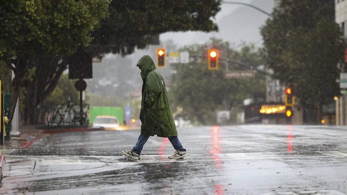 The few people out early were bundled up for rain as puddles formed on Monterey Street. Heavy rain at times fell in downtown San Luis Obispo on Feb. 16, 2026.