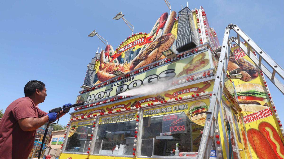 James Gonzalez washes down a hot dog stand as he sets up for the California Mid-State Fair in Paso Robles on Monday, July 19, 2021. The fair runs Wednesday through Aug. 1 at the Paso Robles Event Center.