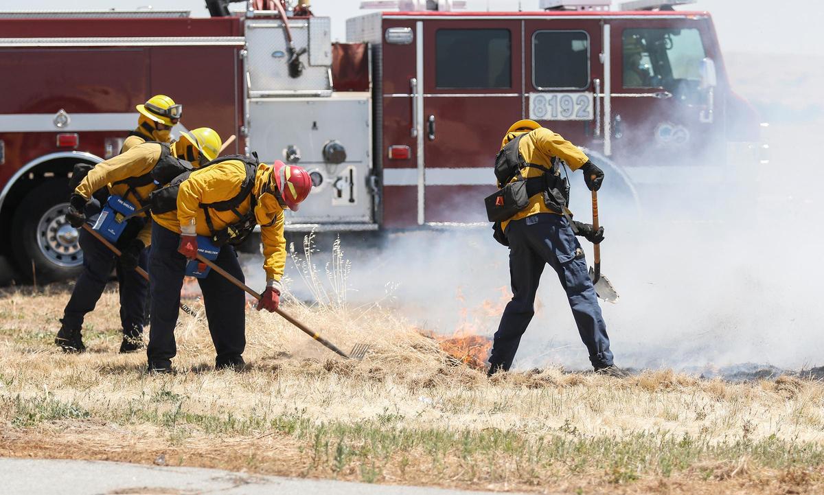The Paso Robles Fire Department conduct live wildland urban interface training drills at the Paso Robles Municipal Airport. Here, a firefighter lights dry grass for the drill.