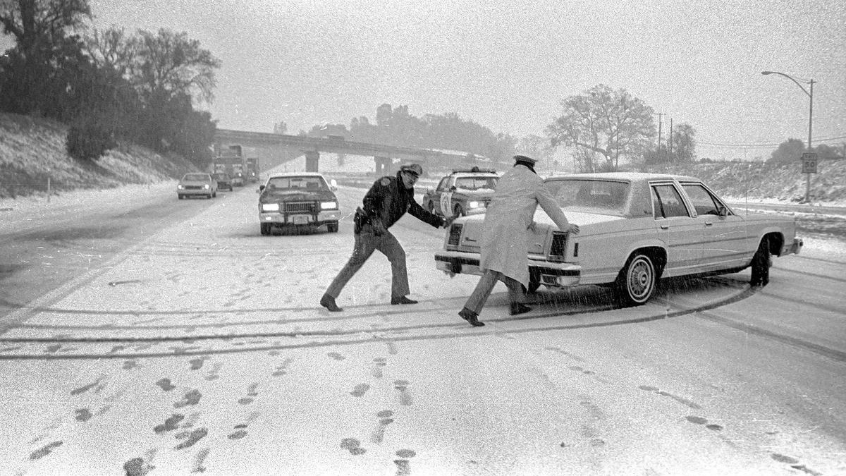 CHP Officer Jim Thompson and Lt. Dick Sabth help a motorist turn around on Highway 101 near Santa Margarita after the Cuesta Grade was closed by snow Dec. 15, 1988.