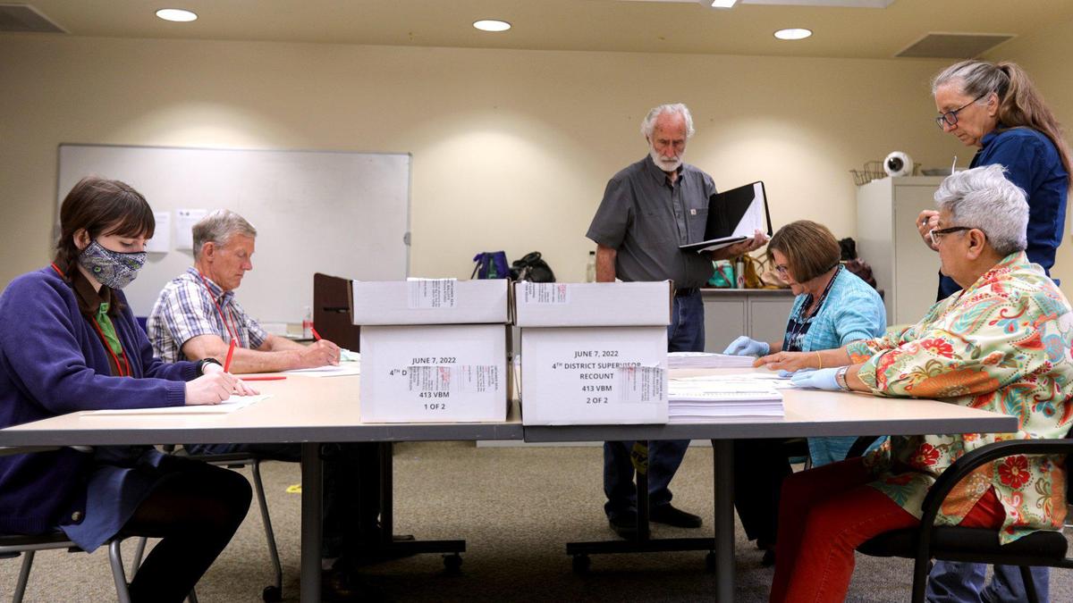 From left, special recount board members Lucia Maceri, Rick Ulsh, Ann Tapper and Rochelle Freidman hand count ballots on Aug. 10, 2022 at the Clerk-Recorder’s Office. Standing are observers Richard Patten and a woman who declined to share her name. The recount was for the San Luis Obispo County Board of Supervisors race between Lynn Compton and Jimmy Paulding.