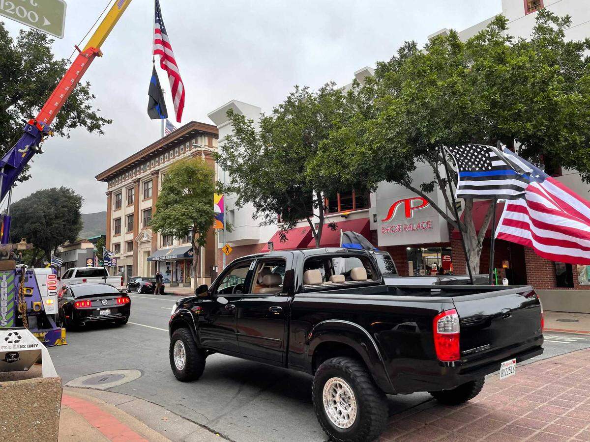 A caravan of vehicles drives through San Luis Obispo ahead of a vigil to honor slain Detective Luca Benedetti on Friday.