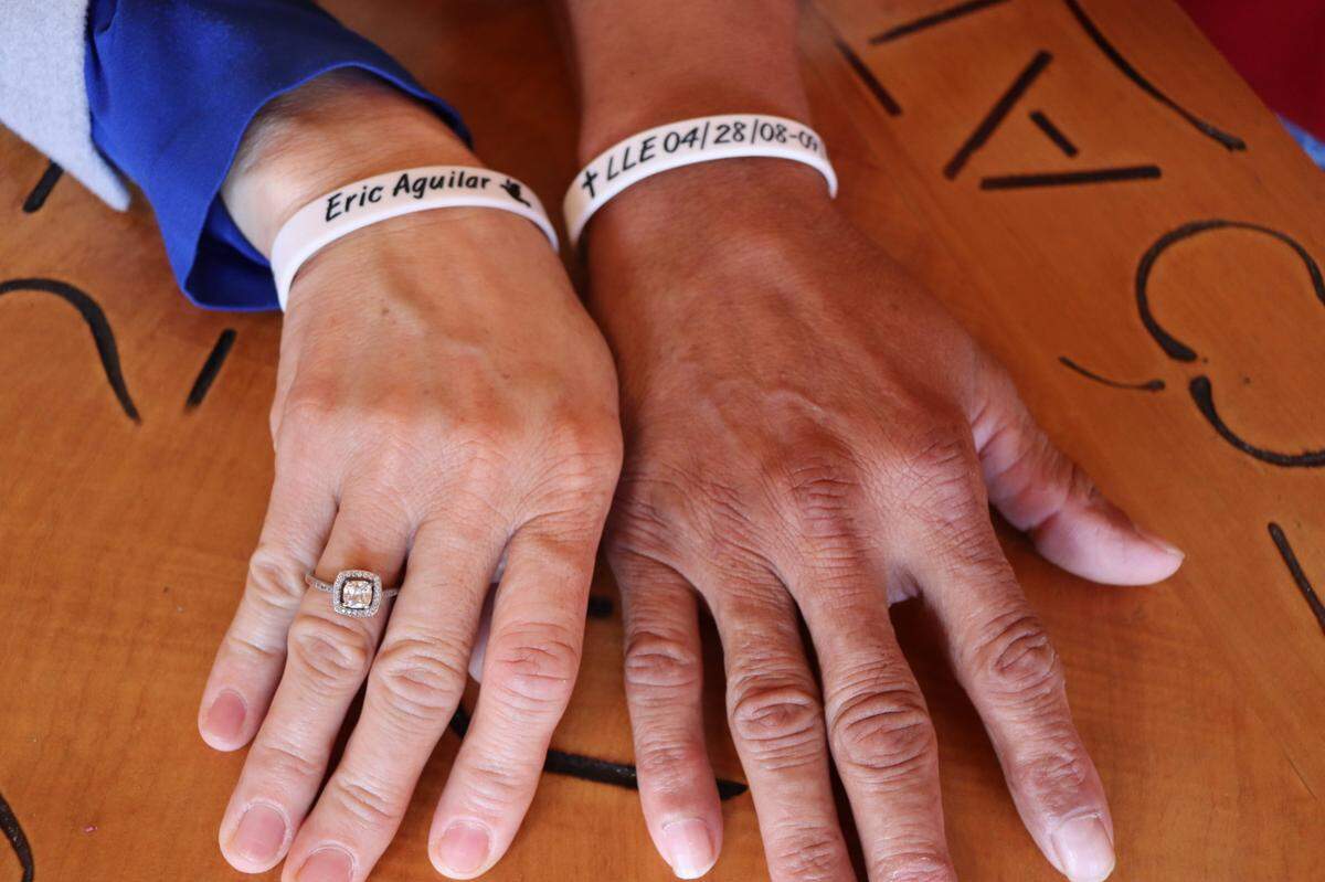 Flor Patricia Miranda and Salvador Aguilar wear bracelets a community member made in remembrance of their son Eric Aguilar’s life after he died in a car crash on Highway 1 on Sept. 14, 2024.