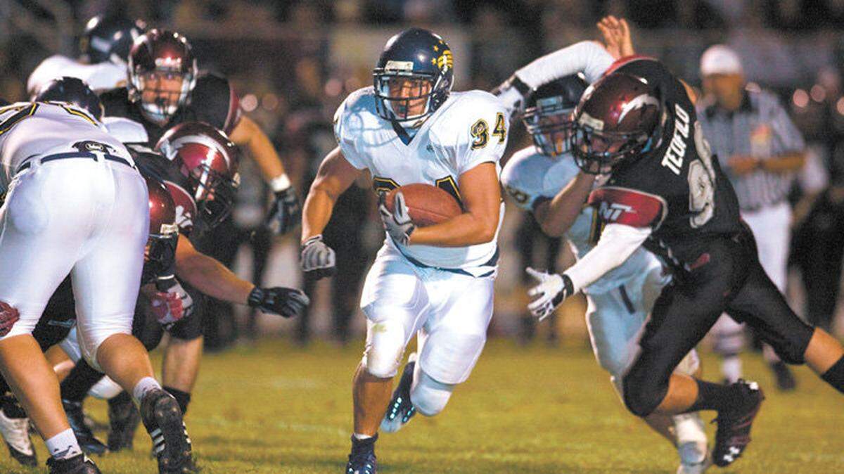 Arroyo Grande High’s Christian Crichton runs through a hole in the Eagles’ 7-0 win at Nipomo last season.