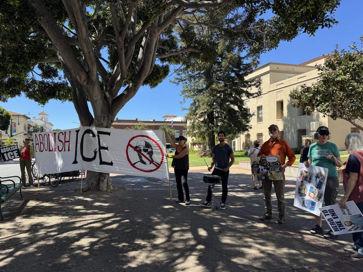 Protesters from Indivisible SLO County hold an “Abolish ICE” sign across the street from the County Government Center on April 7, 2027.