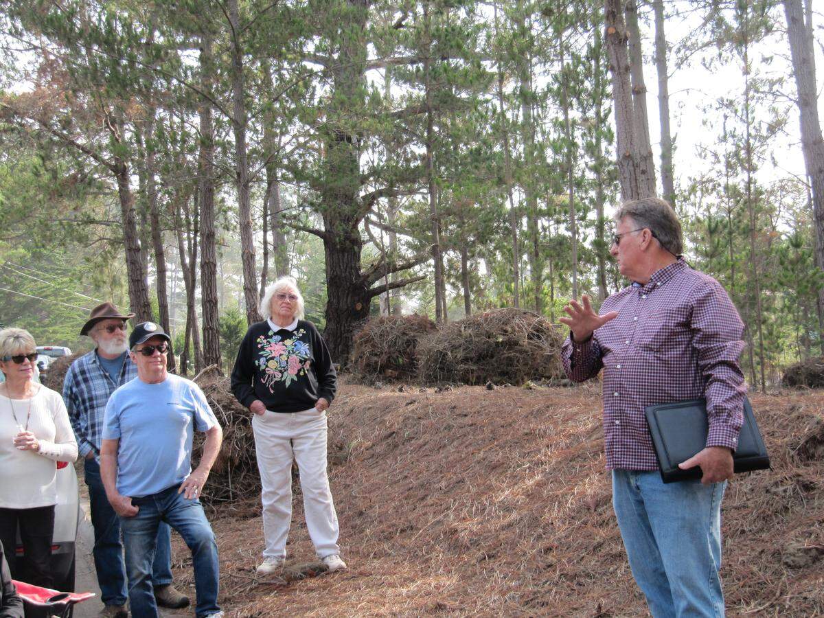 At right, Dan Turner of the county Fire Safe Council and Greg Alex, Cal Fire’s North Coast battalion chief, address a crowd of about 50 Cambria neighbors concerned about fire safety and the agency’s practice of burning piles of collected forest flammables on site. The street-side meeting was held Nov. 17.