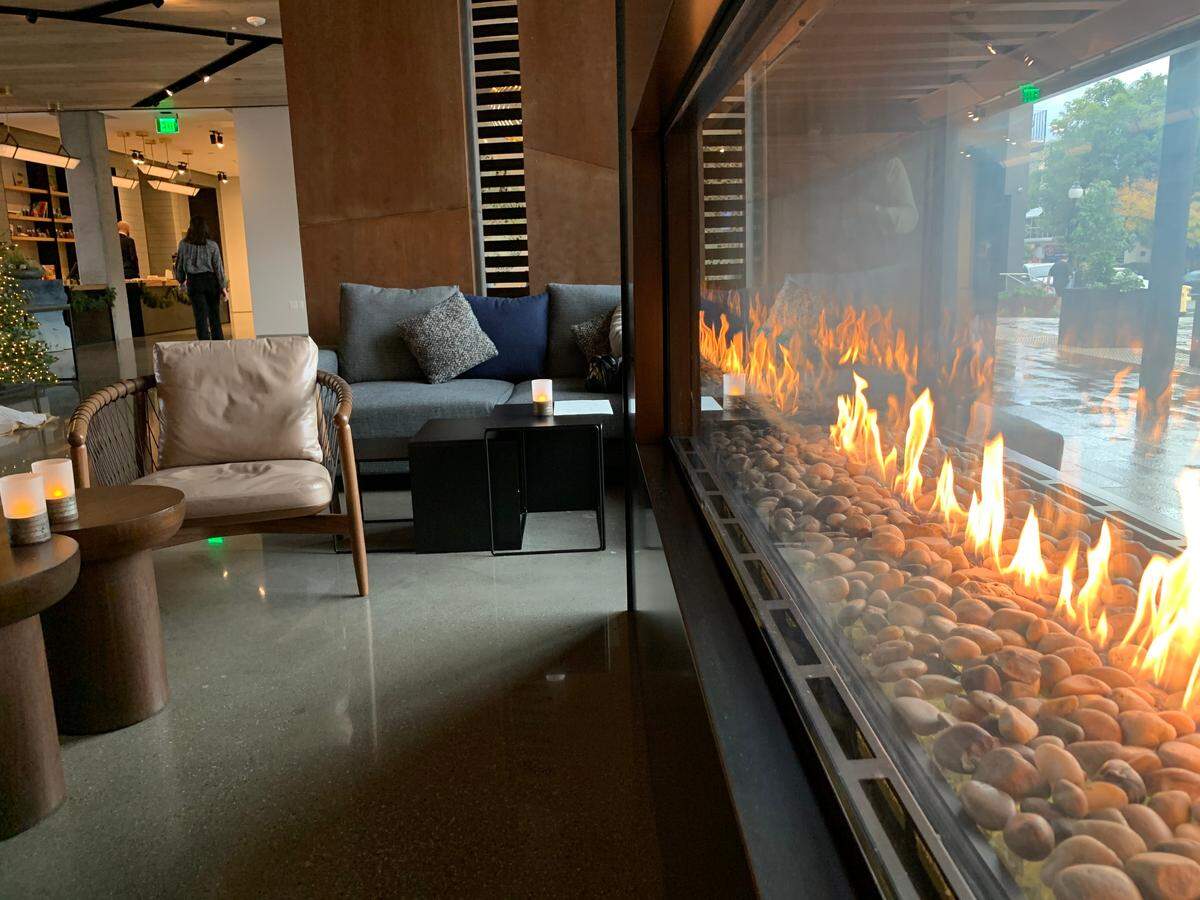 A large see-through fireplace is the centerpiece of the lounge at Hotel San Luis Obispo.