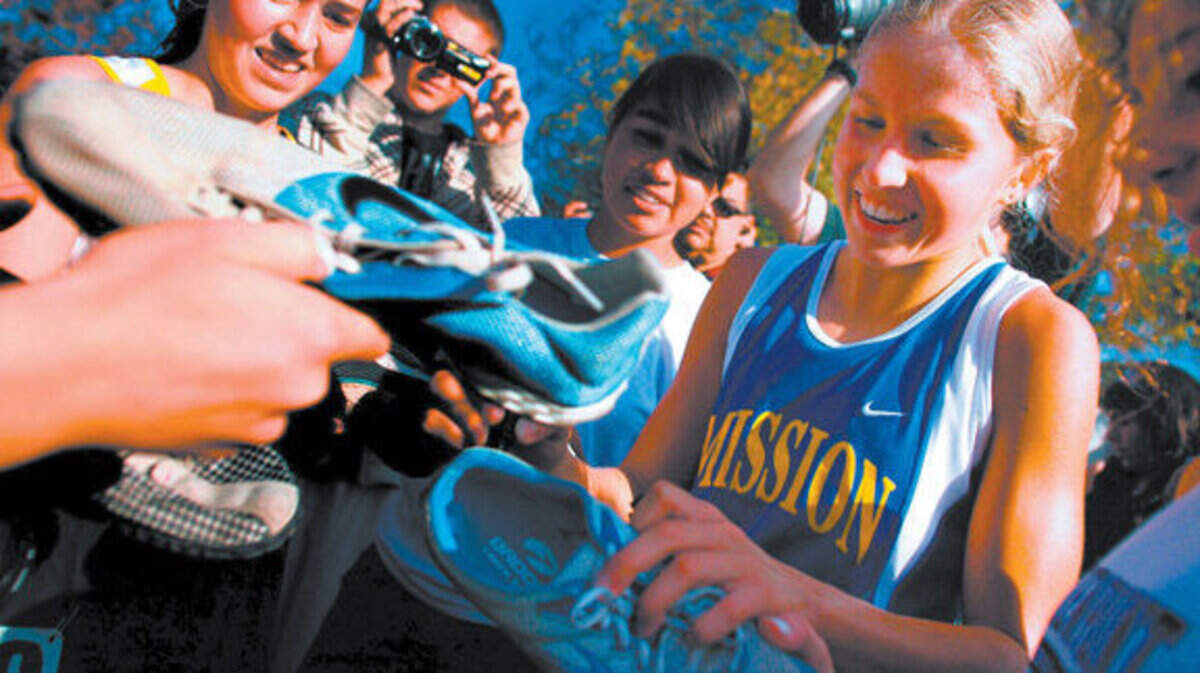 Jordan Hasay autographs competitors’ shoes after she won her fourth straight CIF Division 5 state cross country championship as a high school senior in 2008 at Fresno’s Woodard Park.