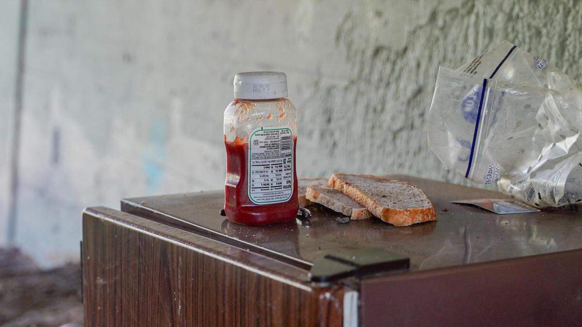 Abandoned food sits on a mini refrigerator in a homeless encampment beneath a Highway 1 overpass in Morro Bay on Feb. 13, 2024. Morro Bay’s new camping ordinance was approved by the City Council in December 2023 and prohibits camping for more than 24 hours in one location or within specific distances of roads, residential areas and some public property.