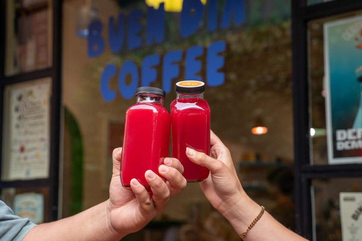 SLO Pressed kitchen manager Iker Ponce and owner Briana Medvecki hold bottles of their appleade juice in front of Buen Dia Coffee in San Luis Obispo on Thursday, May 14, 2026. Medvecki started pressing juice in 2025 as a way to treat acne and other skin irritations.