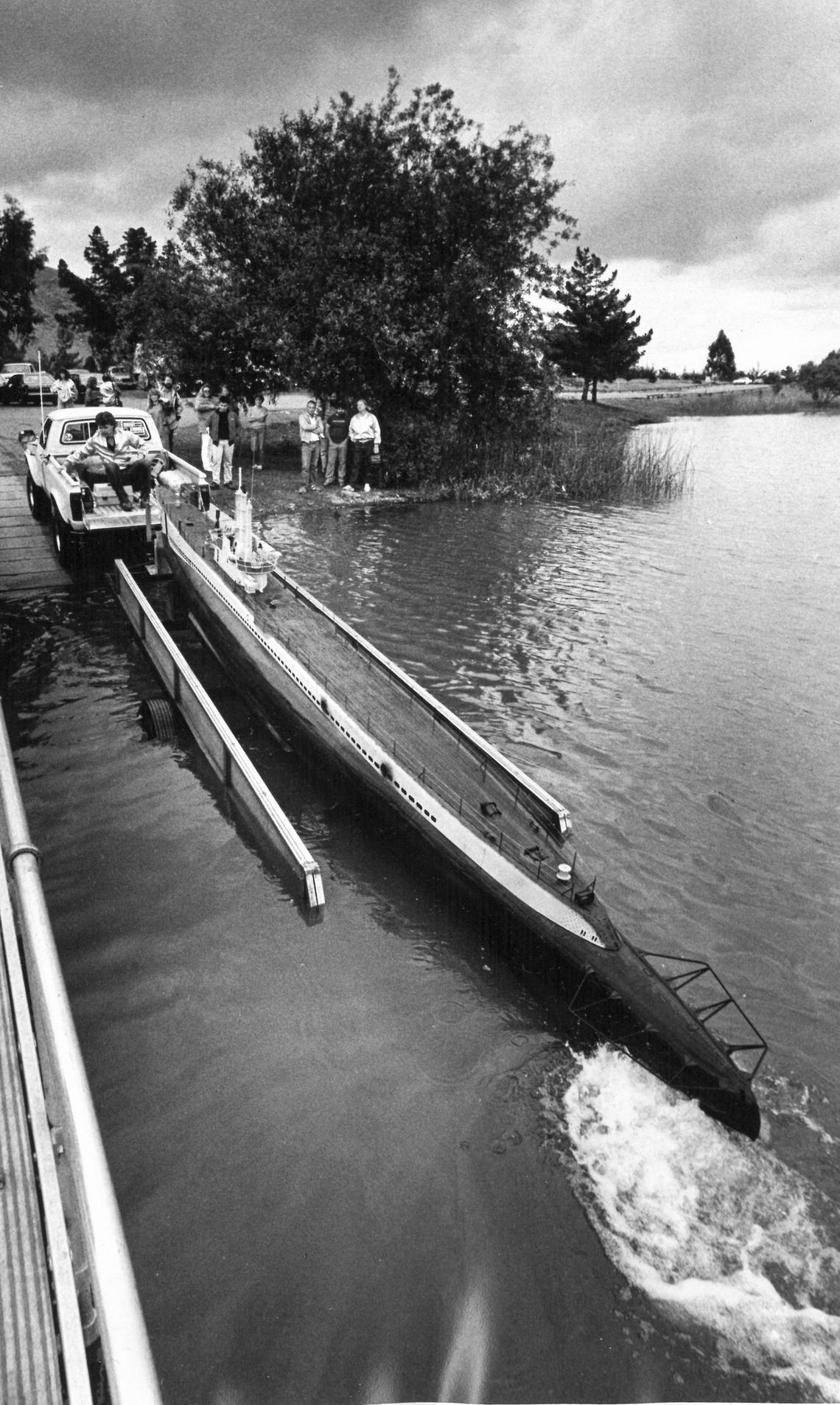 Lonnie Amos steadies the sub as it’s loaded on a trailer after a successful test at Laguna Lake. The 26-foot-long World War II submarine replica was built by Scale Effects in Oceano for the TV series “War and Remembrance.”