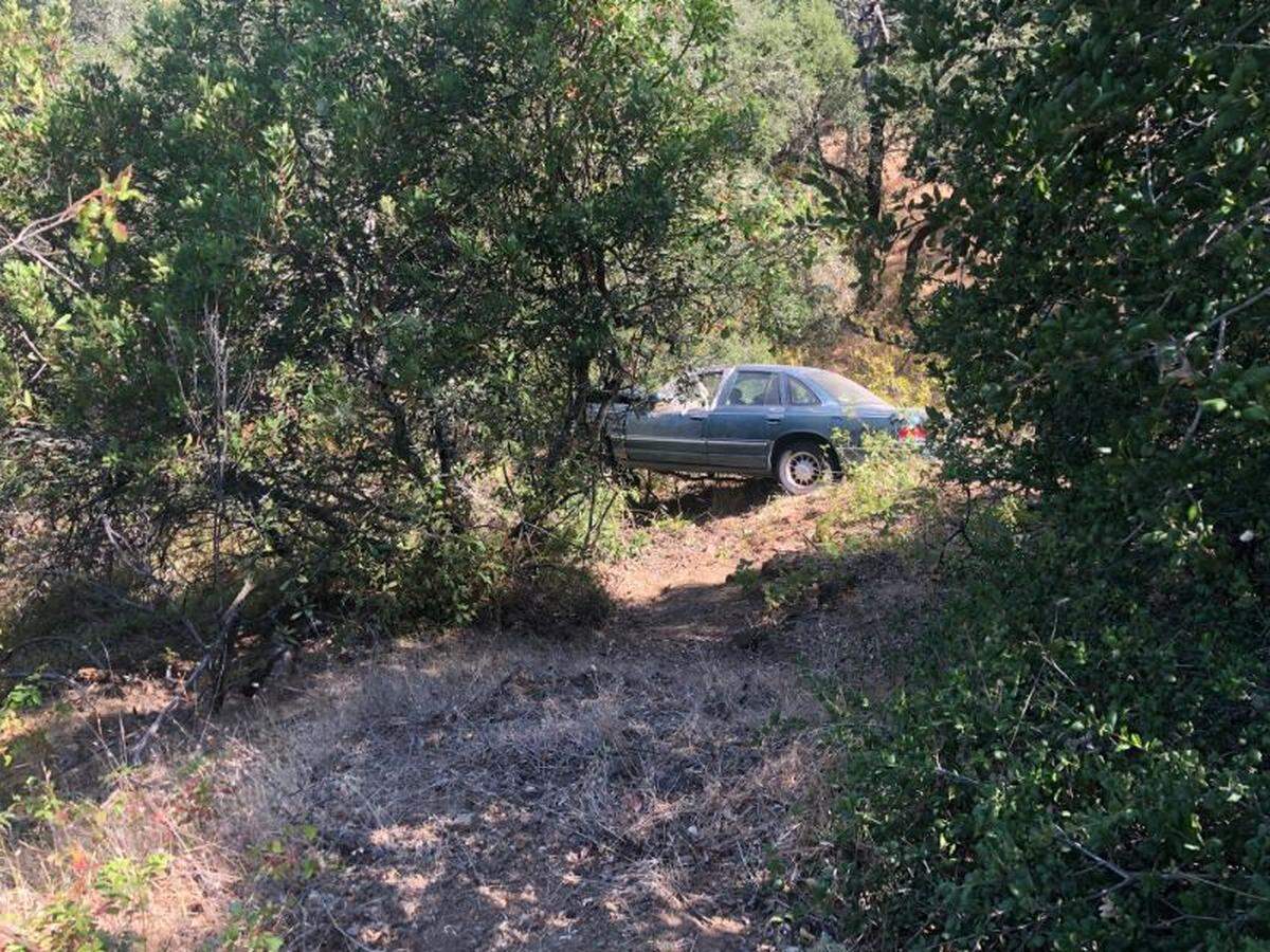 Emergency responders worked Sunday to free a person trapped in a car that plunged 50 feet down an embankment in Atascadero.
