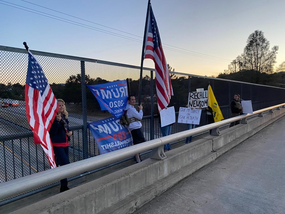 Supporters of President Trump demonstrate with flags and signs Wednesday evening on the Curbaril overpass above Highway 101 in Atascadero.