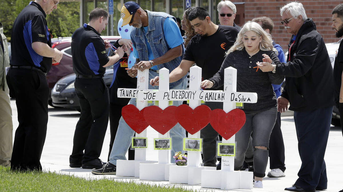 Family members of the four victims killed at a Waffle House restaurant shooting write messages on wooden crosses set up outside the business on April 25, 2018, in Nashville, Tennessee.