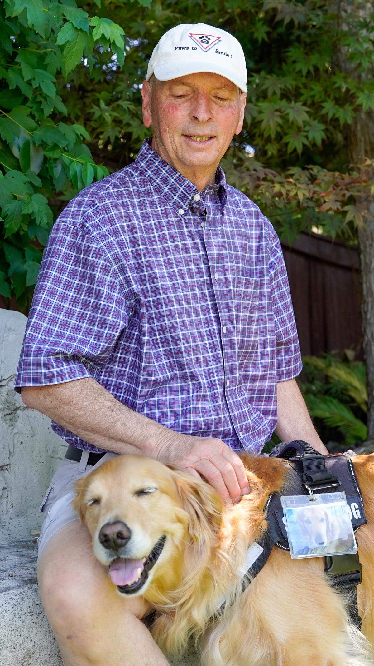 Dan Sievert, founder of Golden Missions of America, pets his service dog, Cooper. Sievert and his golden retrievers have made 55 missions across the United States over the past decade, helping victims of tragedies work through their trauma.