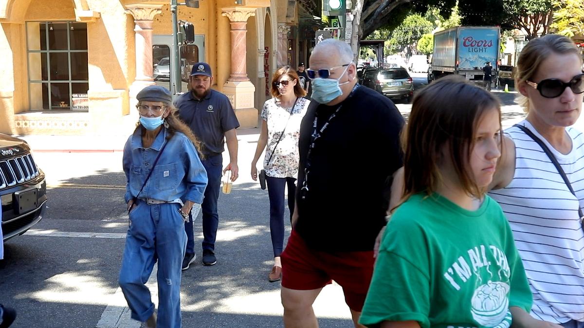 Masked and unmasked people cross the street at Chorro and Higuera streets in San Luis Obispo in June 2021.