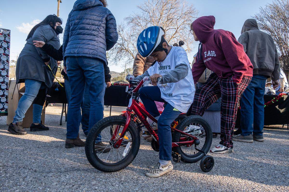 A child tries out their new bike at the San Luis Obispo County Sheriff’s Office bicycle giveaway on Dec. 13, 2022.