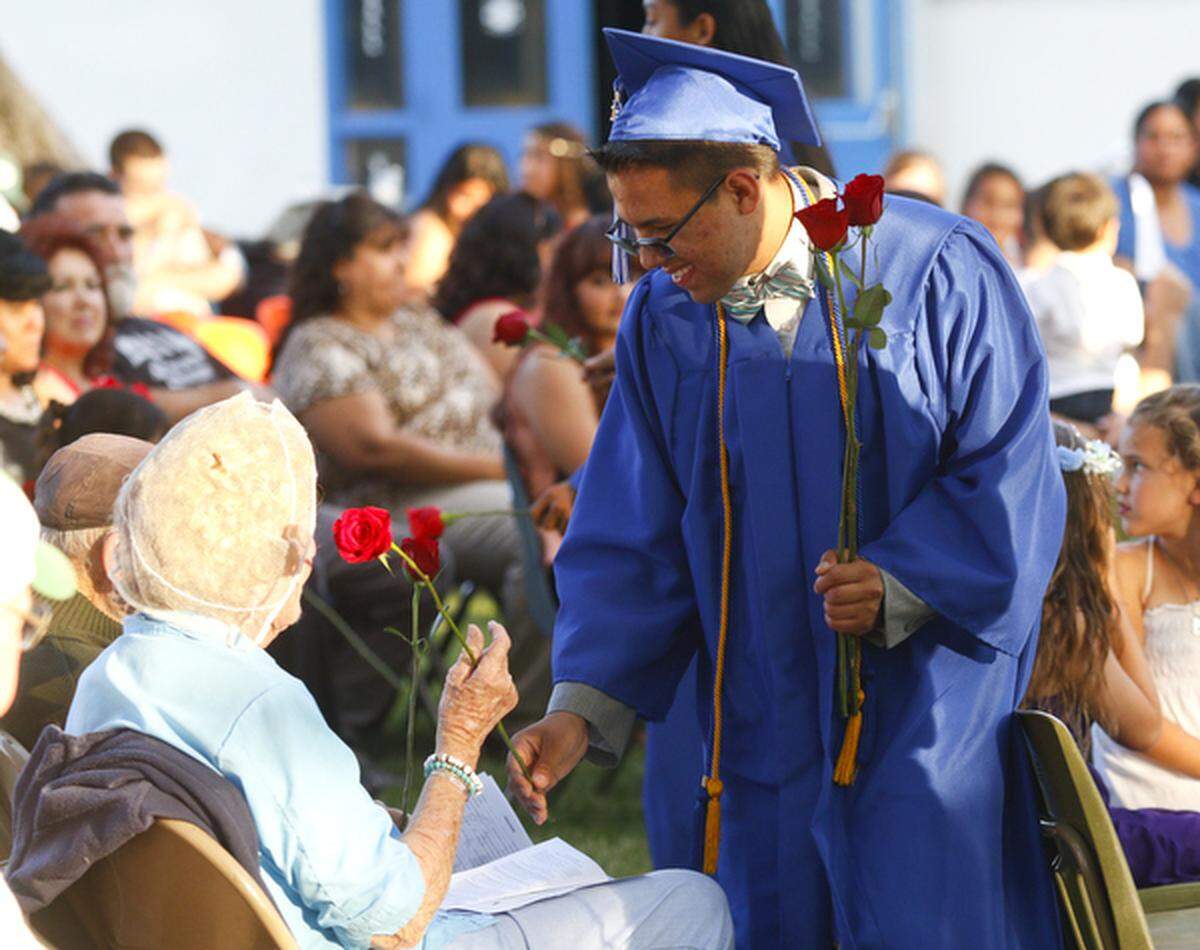 A Shandon High School graduate hands a rose to a loved one during a 2015 ceremony.