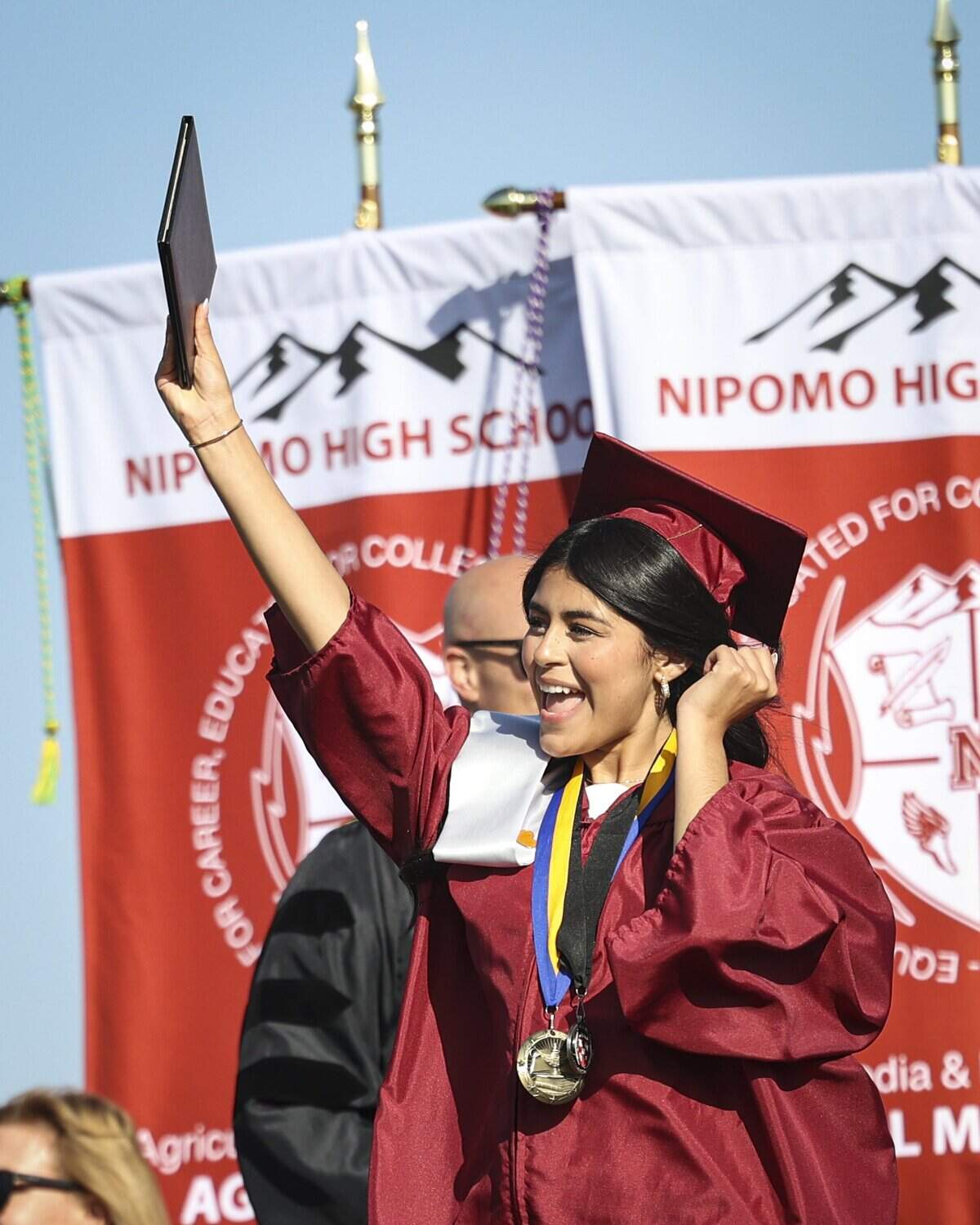 Elisandra Vazquez waves her diploma, principal John Denno is in background. Nipomo High School issued diplomas to 198 graduates on June 5, 2026.