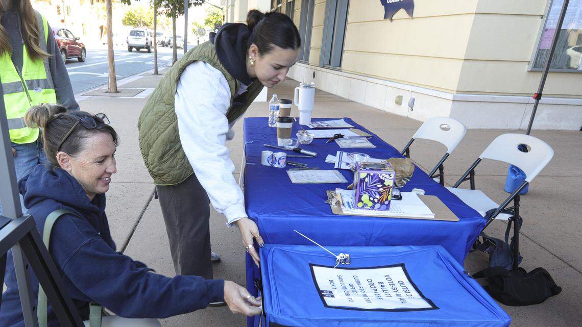 Samantha Montoya, left, drops off ballots for her family. Precinct volunteer Veronique Curutchague helps voters at the San Luis Obispo County Clerk Recorder’s office on Monterey St. on Election Day. Nov. 4, 2025.