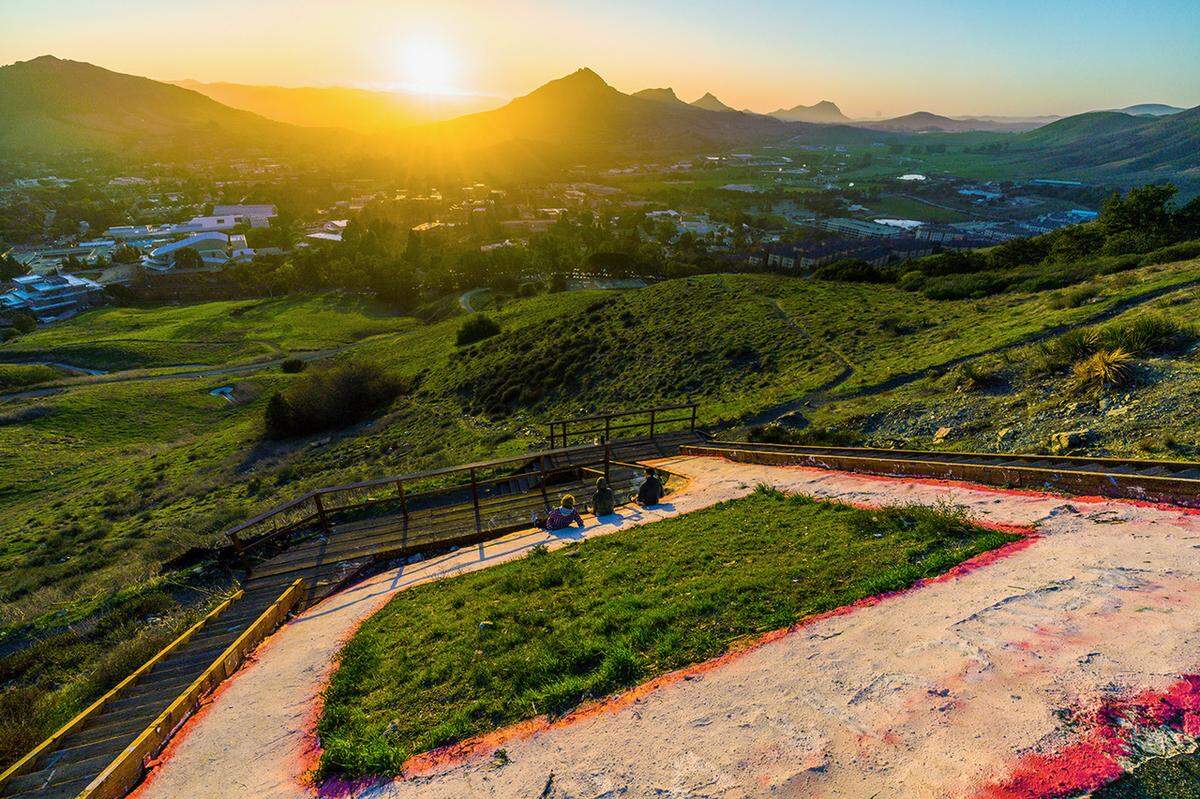 A couple of Cal Poly students watch the sunset from the “Poly P” above San Luis Obispo on Feb. 20, 2020.