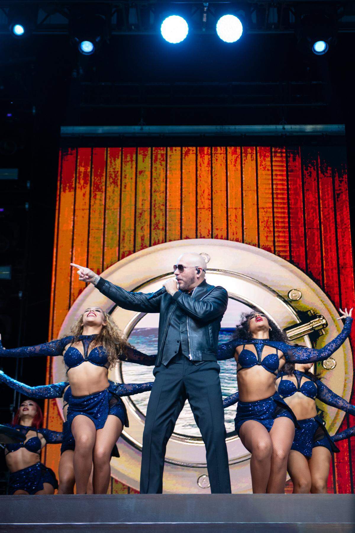 Pitbull, center, performs at the California Mid-State Fair in Paso Robles on Wednesday, July 26, 2023. The singer is surrounded by backup dancers.