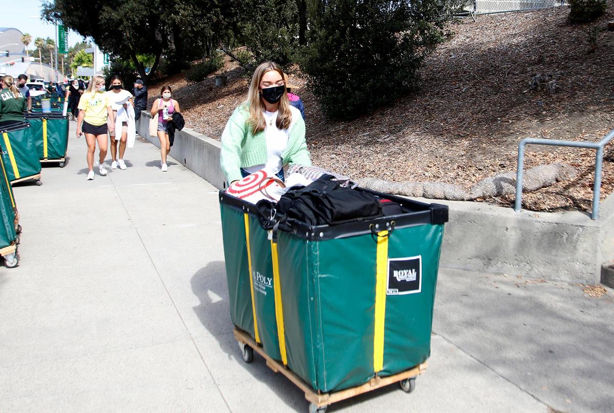 Tessa Zink, a Cal Poly business major, wheels her belongings to Sierra Madre Hall on Tuesday, Sept. 14, 2021. About 8,000 students are expected to move into on-campus housing this week at the San Luis Obispo university.