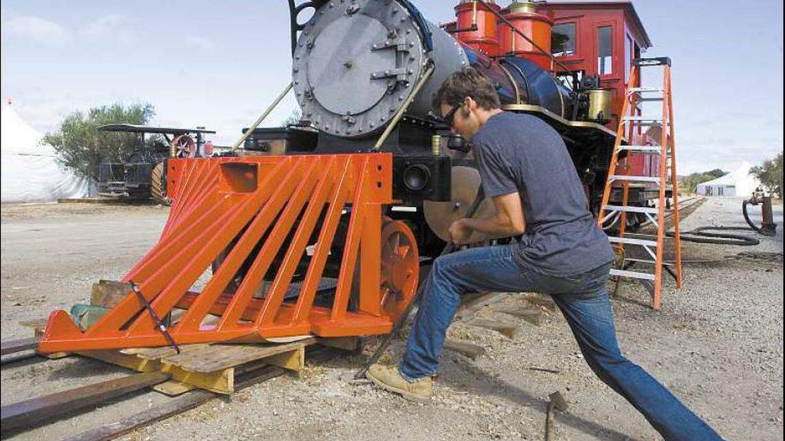 Jeff Tolan installs the pilot (also called the “cow catcher”) on the front of the engine Thursday at the Santa Margarita Ranch.