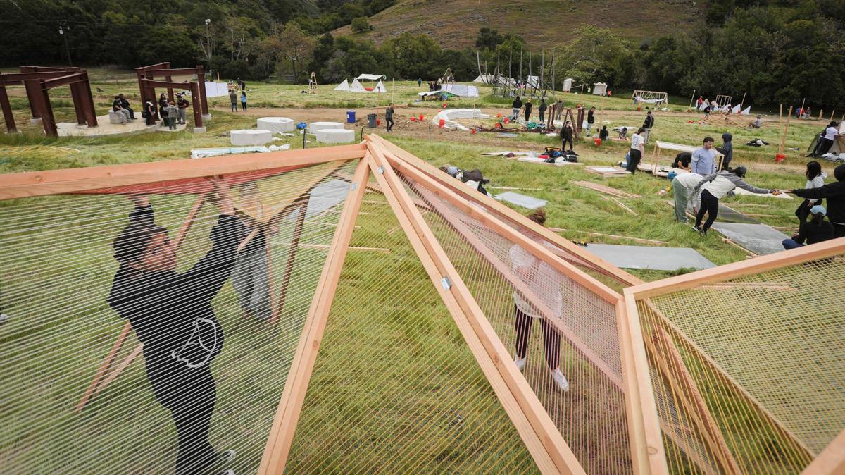 Cuesta College students assemble a hinged wood and yarn structure titled SLOLINK, Ali Karner is at left. Architecture students from throughout the west came to Poly Canyon participate in Design Village on the Cal Poly campus on April 25, 2025.