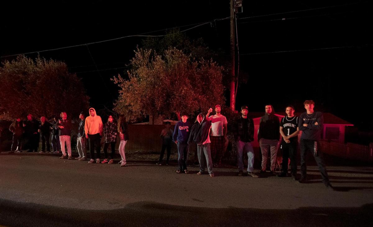 Neighbors and spectators watch the firefighters work. Cal Fire crews are responded to reports of a fully-engaged house fire on 7th Street in Los Osos.