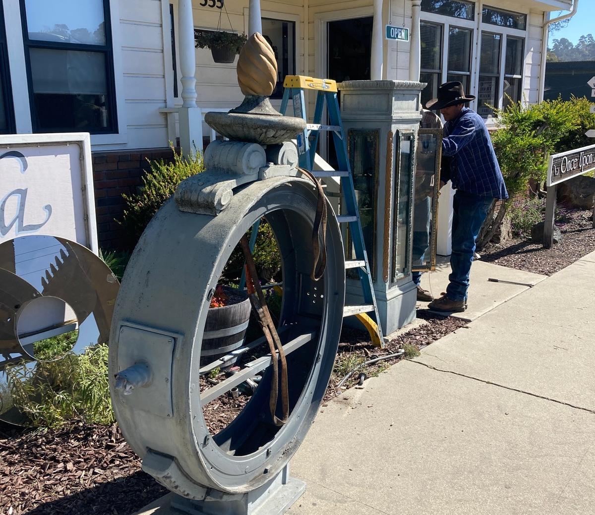 Josh Warren works to disassemble Cambria’s West Village town clock. Sue Foreman — who owns the Once Upon a Tyme clock-and-doll shop/museum adjacent to the historic timepiece standing guard nearby — recently sold the massive town clock that was nicknamed “Big Time.”