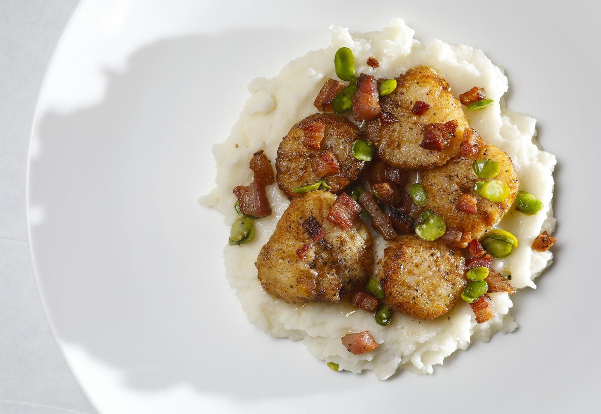 Seared scallops, cauliflower parsnip puree and fava beans are served with a pancetta pan sauce at Park Street Grill, formerly known as Farmstead Kitchen & Catering in Paso Robles.