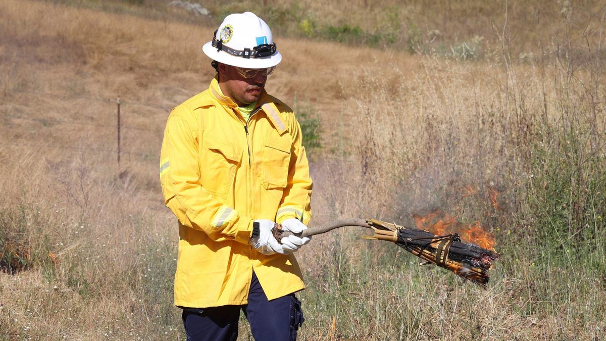 Tyler Mata lights the first corner of the cultural burn with a traditional torch at the Johnson Ranch Open Space on June 18, 2024.