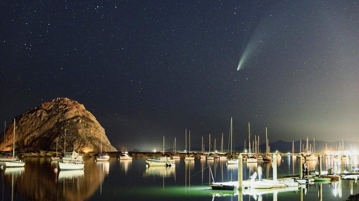 The comet NEOWISE can be seen in the sky over the Morro Bay Harbor on Sunday night.