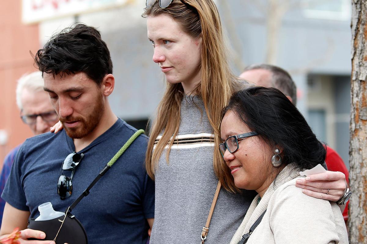 David Kooi, his wife Elizabeth and mother Helen Kooi hug one another at a ceremony to dedicate a ghost bike memorial near Foothill Boulevard in San Luis Obispo honoring David Kooi’s brother, Andreas, on Saturday, Feb. 4, 2023. Andreas Kooi, an incoming Cal Poly graduate student, died after his bicycle was hit by a 17-year-old driver in 2021.