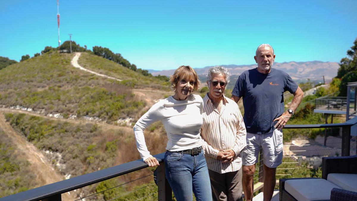 From left, Elizabeth Burkhead, Babak Naficy, and Rogger Emmons stand on Burkhead and Emmons’ porch overlooking the Pismo Preserve and proposed project site of an incoming housing project.