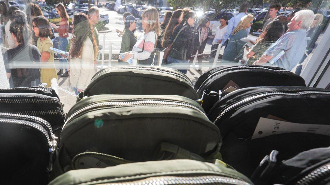 Bags are displayed in the window as people line up outside to see the new Nordstrom Rack store during an invitation-only event on Oct. 24, 2023. The store is in the SLO Promenade near REI, Sprouts and Hobby Lobby.
