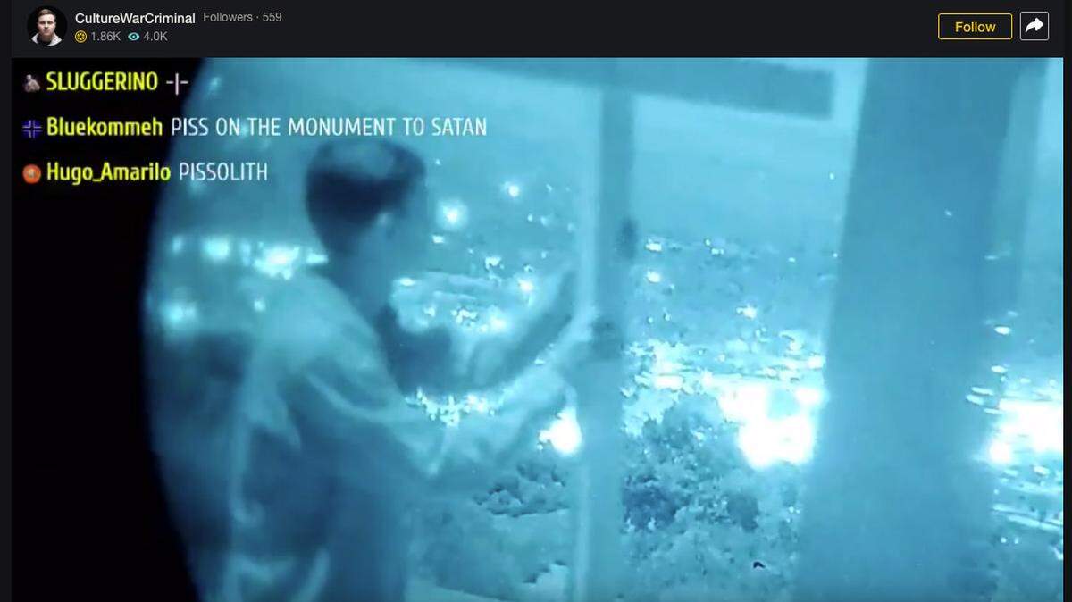A group of young men drove from Southern California to Atascadero to topple the monolith on Pine Mountain early Thursday morning. Here, one holds the wooden cross they left in its place, while he looks out over the lights of the city.