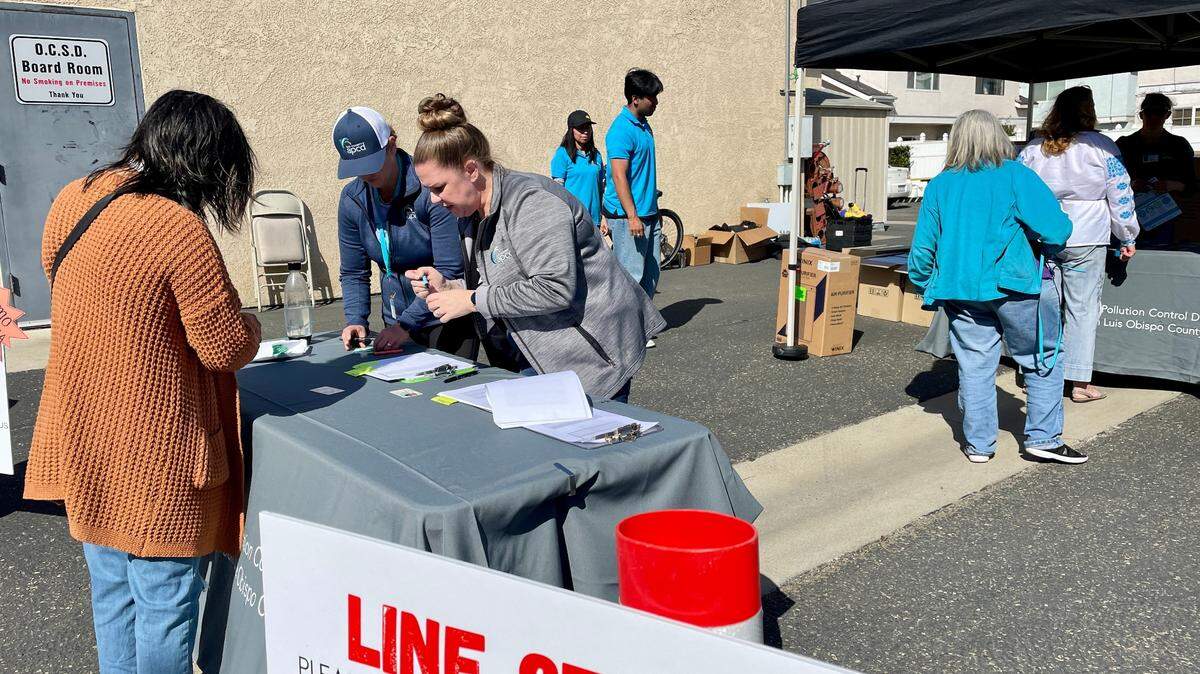 People line up to receive a free air purifier from the San Luis Obispo County Air Pollution Control District at the Oceano Community Services District office. The air purifiers are being given to low-income residents in Oceano and on the Nipomo Mesa to help ease indoor air pollution from the Oceano Dunes and wildfires.
