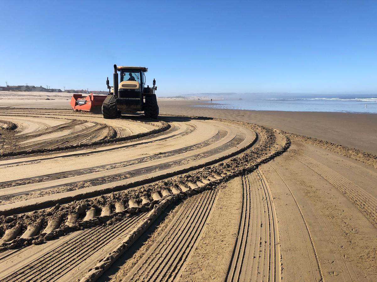 A tractor conducting grading work below the mean high tide on June 14, 2021, at Oceano Dunes State Vehicular Recreation Area after the California Coastal Commission banned such action.