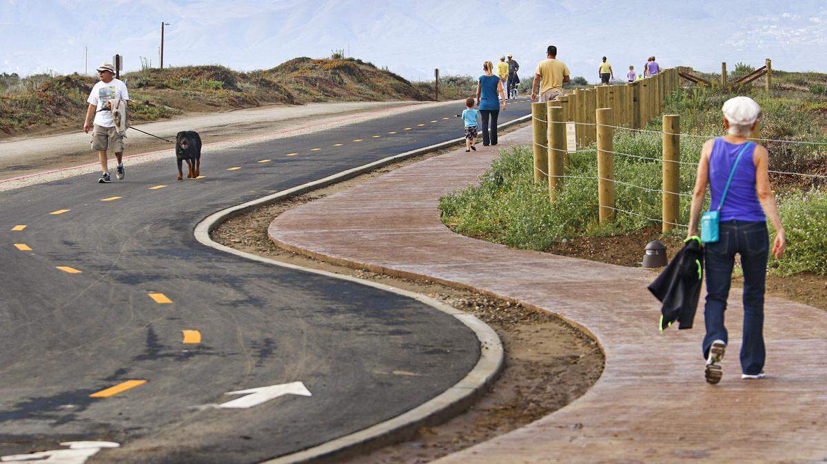 Pedestrians walk along a recently opened addition to Morro Bay’s multi-use trail, which links the Embarcadero to north Morro Bay.