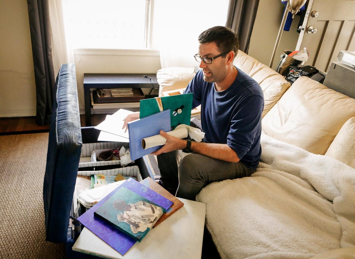 Tom Whaley looks through a few of his wife Christine’s unfinished pieces of artwork.