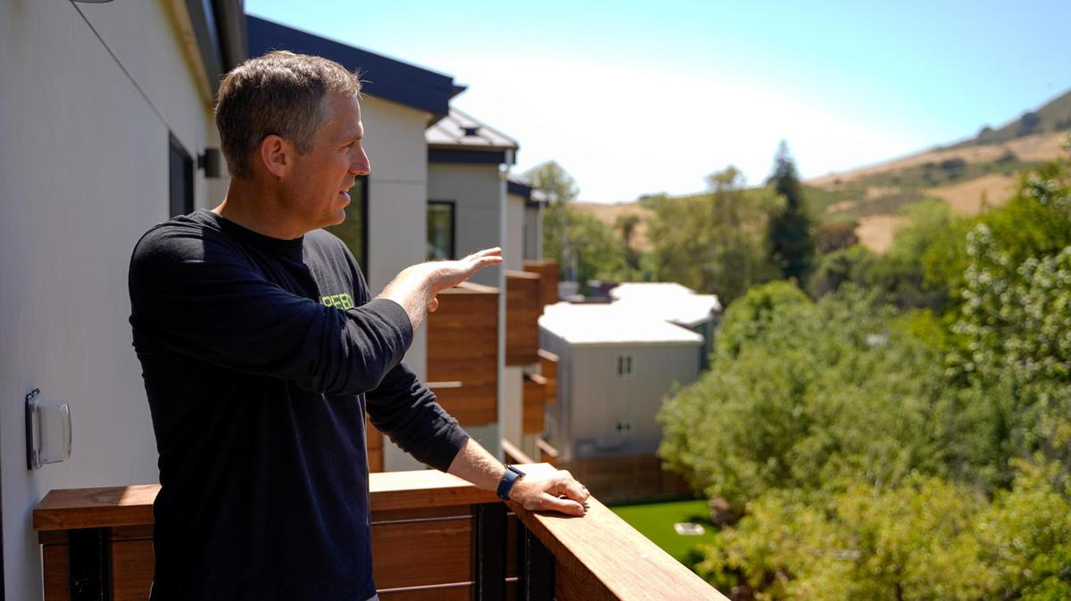 Abbot Reed developer Aaryn Abbot stands on a top-level balcony of the newly-finished Artisan Apartments in downtown San Luis Obispo, pictured Thursday, June 12, 2025. The new 36-unit apartment complex utilizes an all-electric design and dense, tall infill techniques to place the units on a small lot along San Luis Obispo Creek.