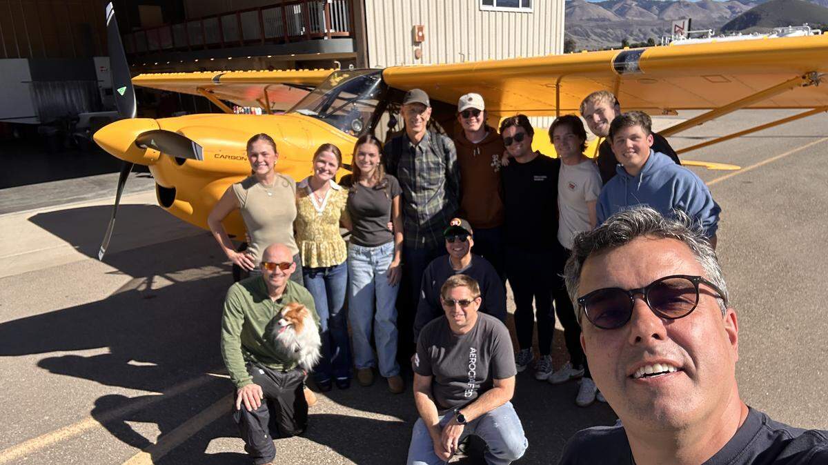 Cal Poly aerospace engineering Professor Paulo Iscold, right, stands with his flight test class at the San Luis Obispo County Regional Airport, following a record-breaking, high-altitude flight on Oct. 28. The Carbon Cub UL plane sits in the background.