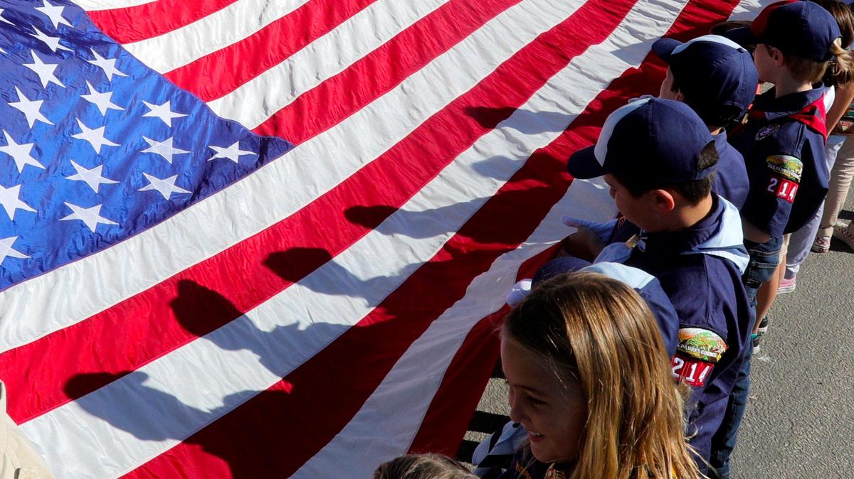 Various scouting organizations carried a large American flag during a Veterans Day ceremony at Los Osos Valley Mortuary and Memorial Park on Monday.