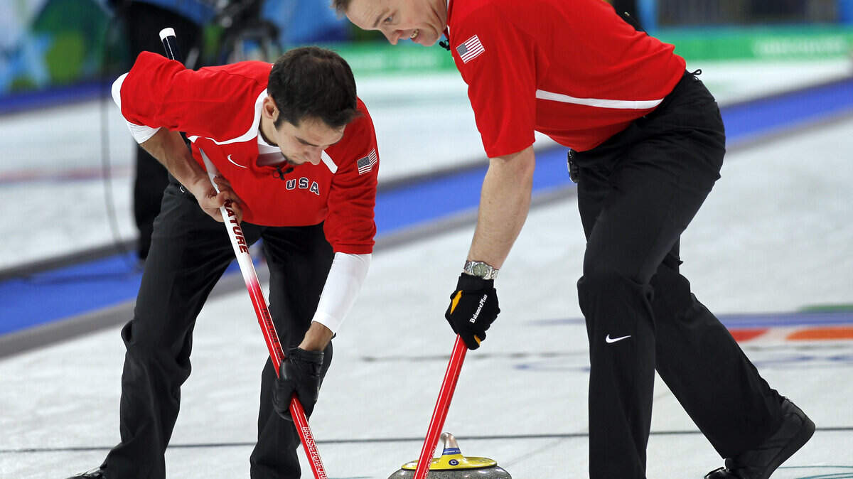 USA's Jason Smith, left and John Benton work to control their rock during their match against France. (Harry E. Walker / MCT)