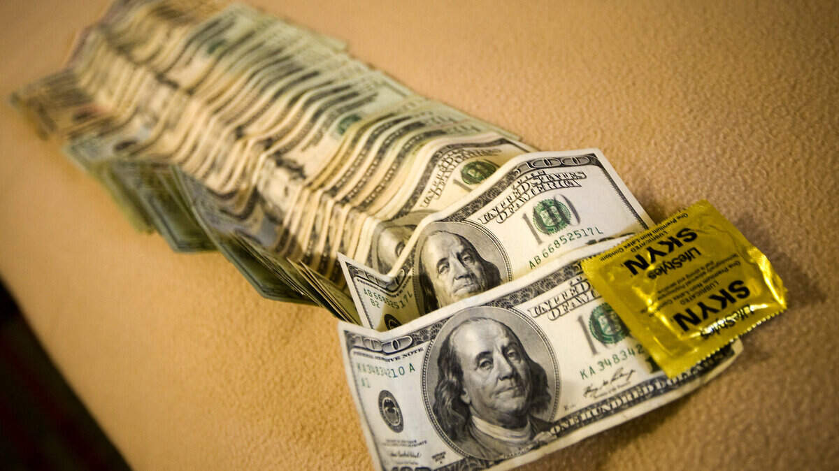 Cash and a condom are laid out on a motel bed while being processed as evidence during Thursday's sting in San Luis Obispo.